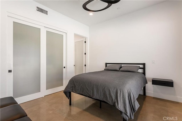 bedroom with recessed lighting, visible vents, baseboards, finished concrete flooring, and a closet