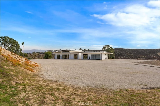 view of front of property with a garage, driveway, and a mountain view