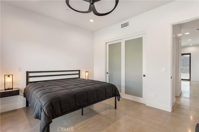 bedroom with recessed lighting, concrete floors, visible vents, baseboards, and a closet