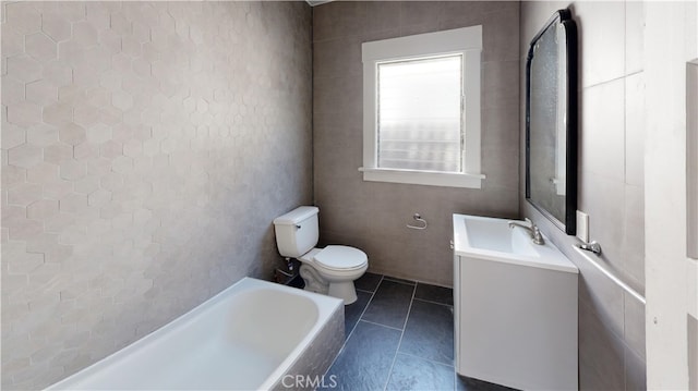 full bathroom featuring a bathtub, tile patterned flooring, vanity, and toilet