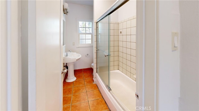 bathroom with enclosed tub / shower combo, toilet, and tile patterned floors