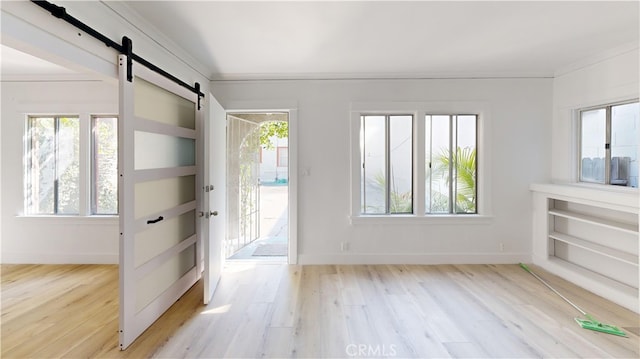 entryway with wood finished floors, baseboards, and a barn door