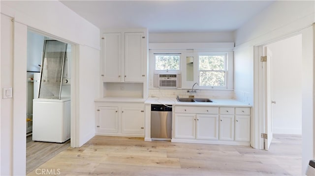 kitchen featuring white cabinets, dishwasher, light wood-style flooring, light countertops, and a sink