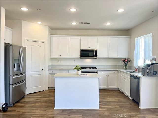 kitchen with visible vents, dark wood-style floors, stainless steel appliances, white cabinets, and light countertops