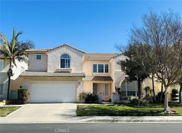 mediterranean / spanish house featuring driveway, an attached garage, a tiled roof, and stucco siding