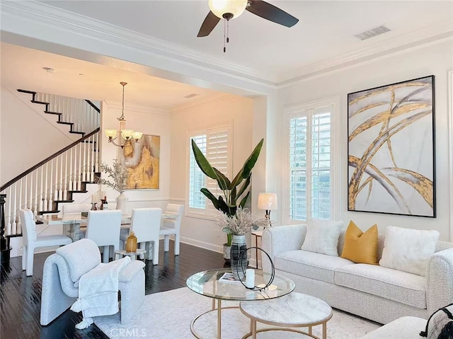 living area featuring wood finished floors, visible vents, baseboards, stairs, and crown molding