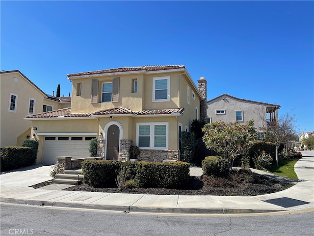 mediterranean / spanish-style home featuring a tile roof, stucco siding, a garage, stone siding, and driveway