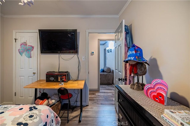 bedroom featuring ornamental molding, baseboards, and wood finished floors