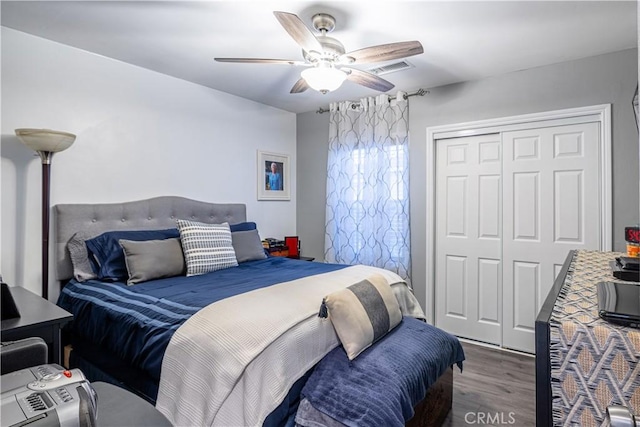 bedroom featuring ceiling fan, a closet, wood finished floors, and visible vents