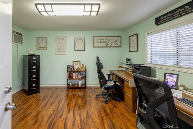 office featuring a wall mounted AC, wood finished floors, and baseboards