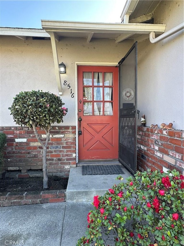 entrance to property with stucco siding and brick siding