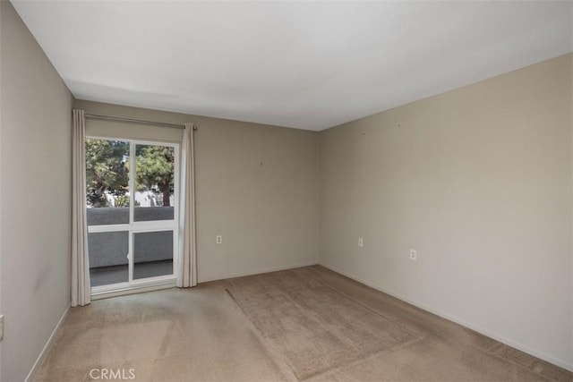 carpeted empty room with baseboards