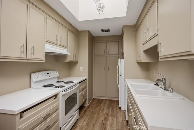 kitchen with light countertops, light wood-style flooring, a sink, white appliances, and under cabinet range hood