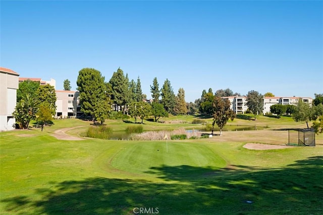 view of property's community featuring golf course view and a yard