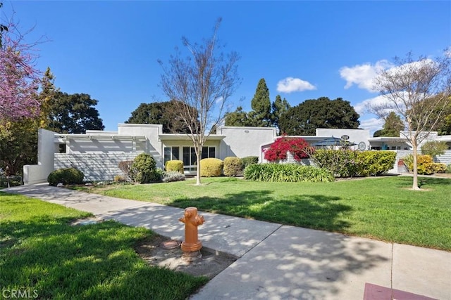 view of front of house featuring a front yard and stucco siding