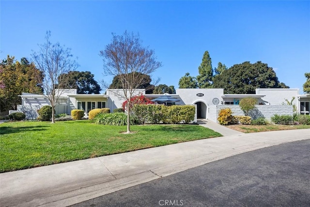 ranch-style home featuring a front lawn