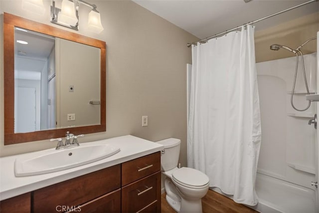 full bath with toilet, curtained shower, wood finished floors, and vanity