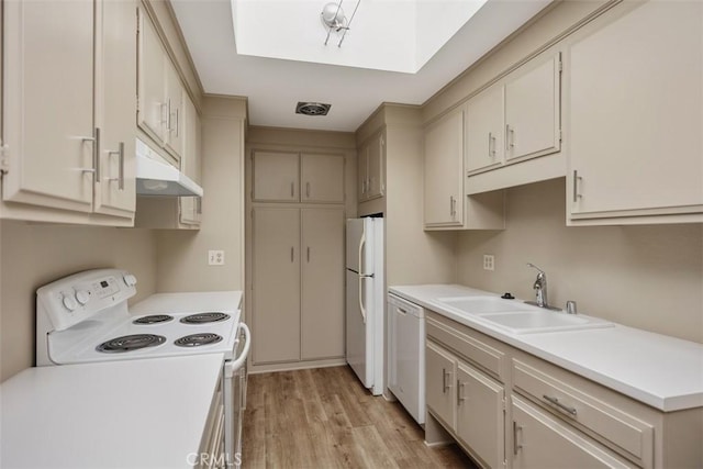 kitchen featuring light countertops, white appliances, a sink, and under cabinet range hood