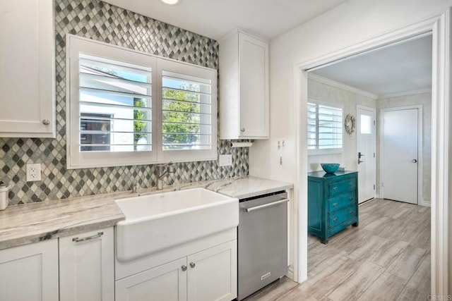 kitchen featuring crown molding, light wood-style flooring, decorative backsplash, stainless steel dishwasher, and white cabinetry