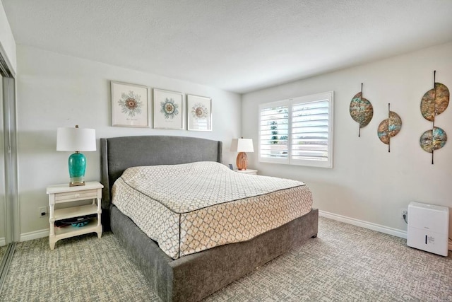 carpeted bedroom with a textured ceiling and baseboards