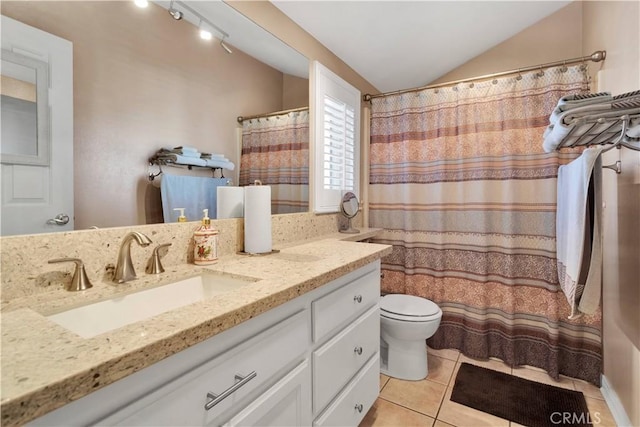 bathroom with lofted ceiling, toilet, tile patterned flooring, and vanity