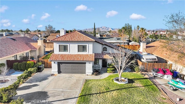 view of front of house with a tile roof, stucco siding, an attached garage, fence, and driveway