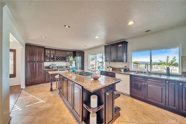 kitchen with white dishwasher, a sink, decorative backsplash, light stone countertops, and open shelves