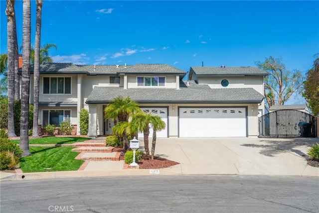 view of front of house with a gate, an attached garage, and concrete driveway