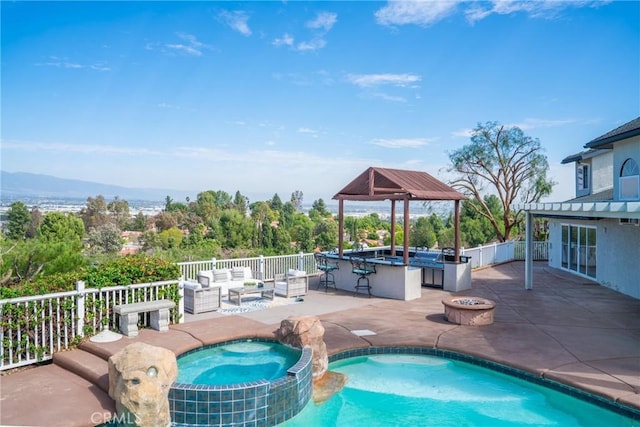 view of swimming pool featuring an outdoor living space with a fire pit, outdoor dry bar, fence, a patio area, and a pool with connected hot tub