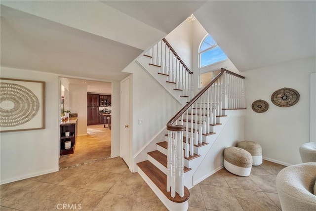 stairs with baseboards and tile patterned floors