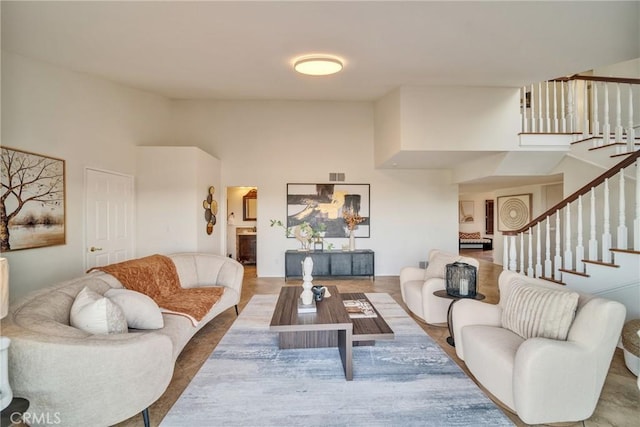 living area with stairway and a towering ceiling