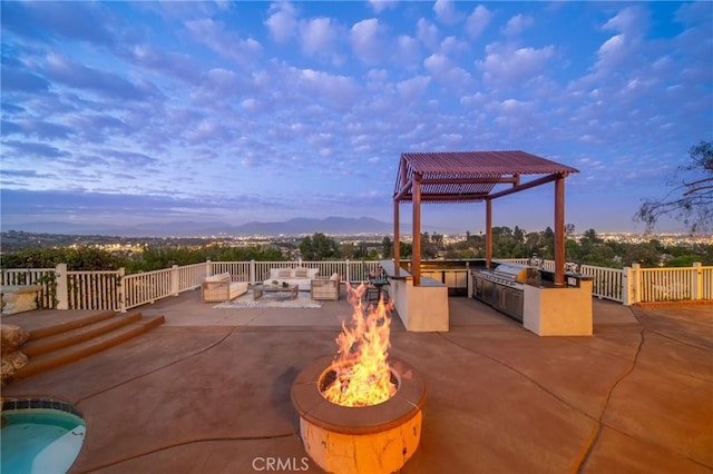 view of patio / terrace with an outdoor fire pit and an outdoor kitchen