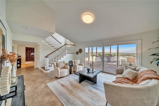 living room with stairs and high vaulted ceiling