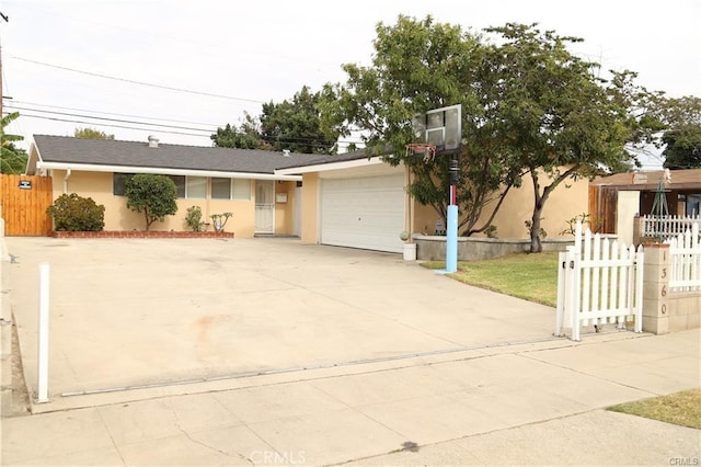 single story home with fence, driveway, an attached garage, and stucco siding