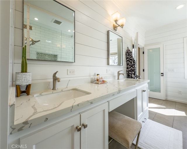 bathroom featuring double vanity, a sink, visible vents, and tile patterned floors