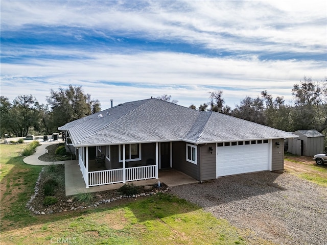 single story home with a garage, a shingled roof, a sunroom, a front yard, and gravel driveway