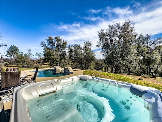 pool with a hot tub and a patio