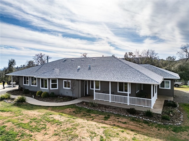 back of property featuring a shingled roof and a porch