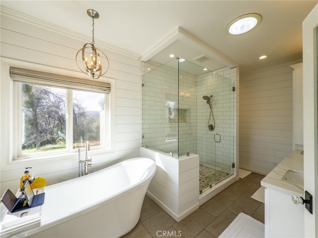 full bathroom with a freestanding bath, wood walls, a shower stall, vanity, and tile patterned floors