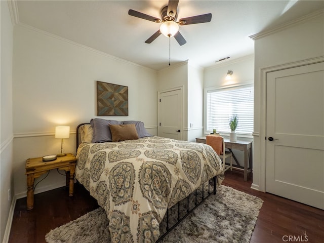 bedroom featuring baseboards, visible vents, dark wood finished floors, ceiling fan, and ornamental molding