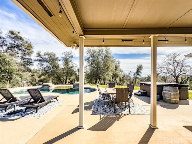 view of patio with a hot tub, an outdoor pool, and outdoor dining space