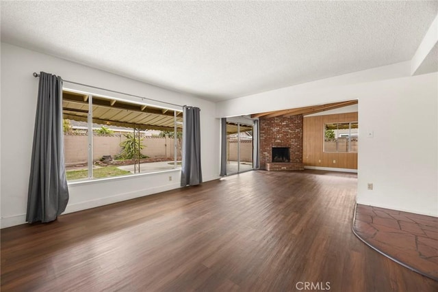 unfurnished living room featuring a textured ceiling, a fireplace, and wood finished floors