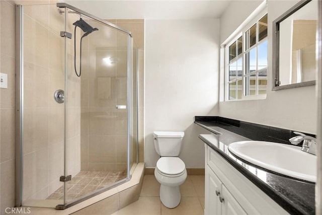 bathroom featuring a stall shower, tile patterned flooring, vanity, and toilet