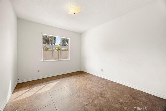 empty room featuring baseboards and a textured ceiling