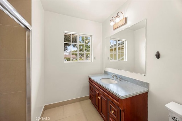 bathroom featuring tile patterned flooring, baseboards, vanity, and toilet