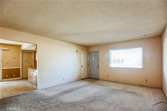 carpeted empty room featuring a textured ceiling