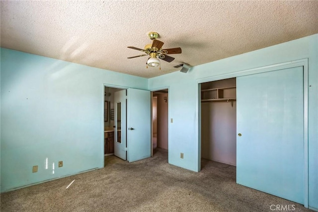 unfurnished bedroom with a textured ceiling, carpet floors, a closet, and a ceiling fan