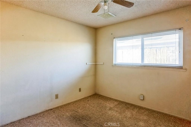 carpeted empty room with ceiling fan and a textured ceiling