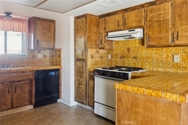 kitchen featuring black dishwasher, gas range oven, visible vents, backsplash, and under cabinet range hood