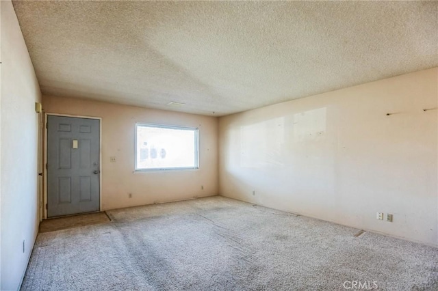 carpeted spare room featuring a textured ceiling